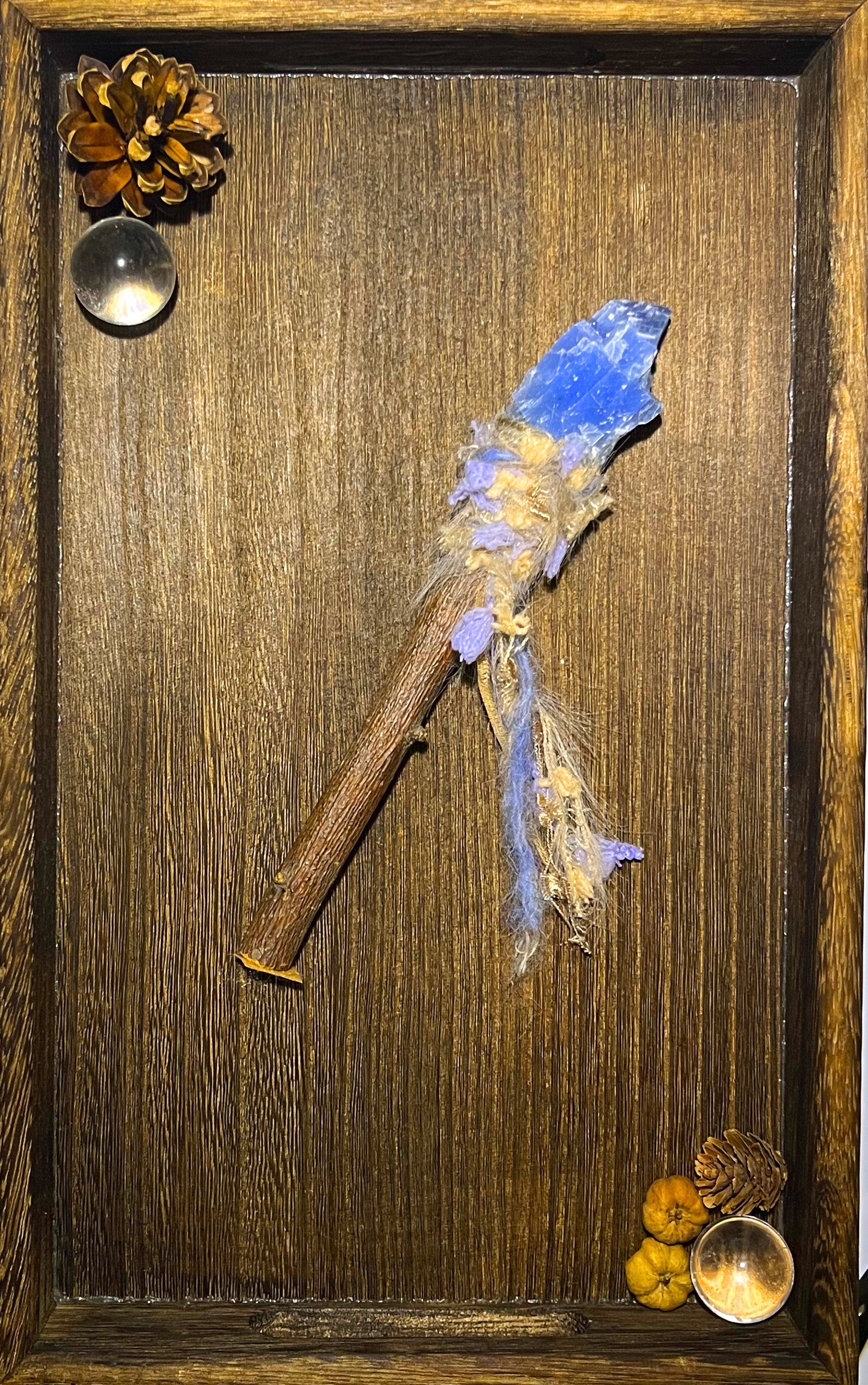 Flat lay of healing dreamwork wand with soft threads and raw blue calcite