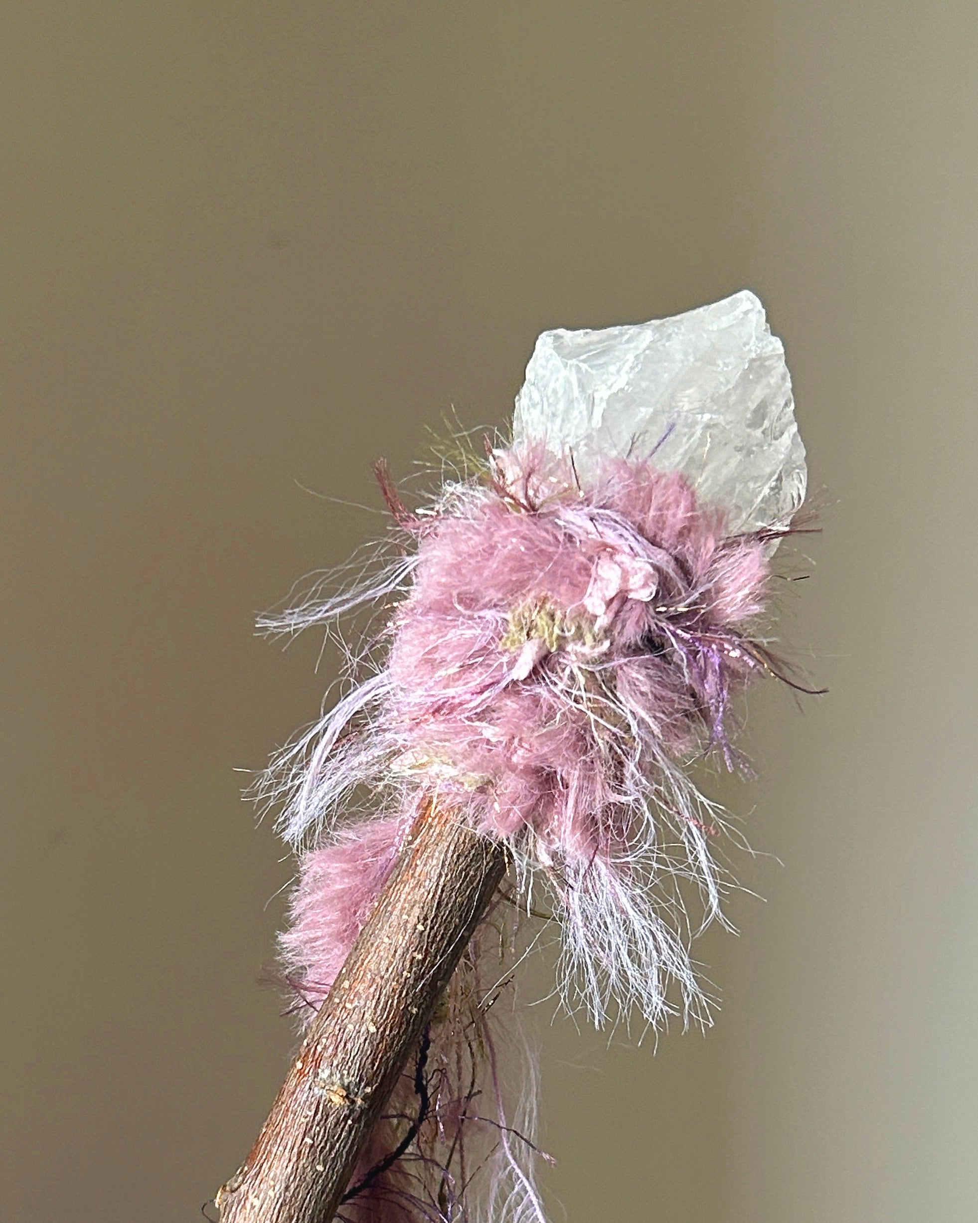 Front view of applewood wand with raw clear quartz and dusty pink-lavender fibers