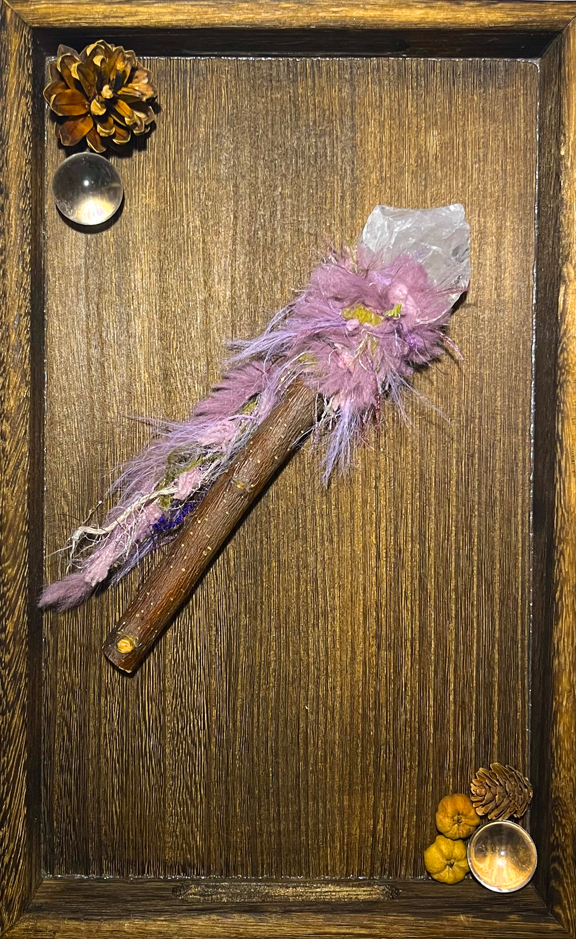 Flat lay of applewood healing wand with clear quartz on a neutral altar plate