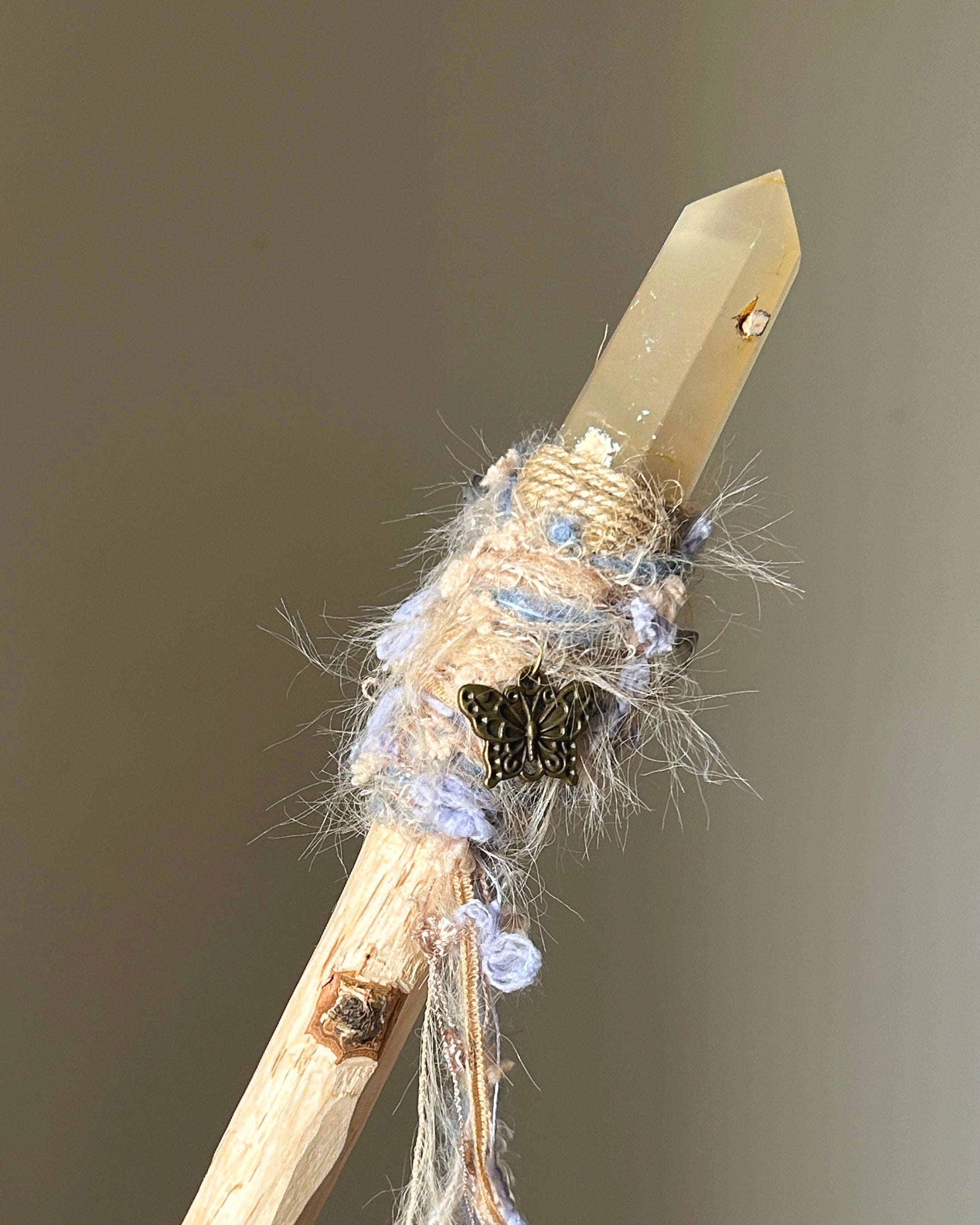 Back view of wand with silver butterfly charm and pale lavender yarn flow