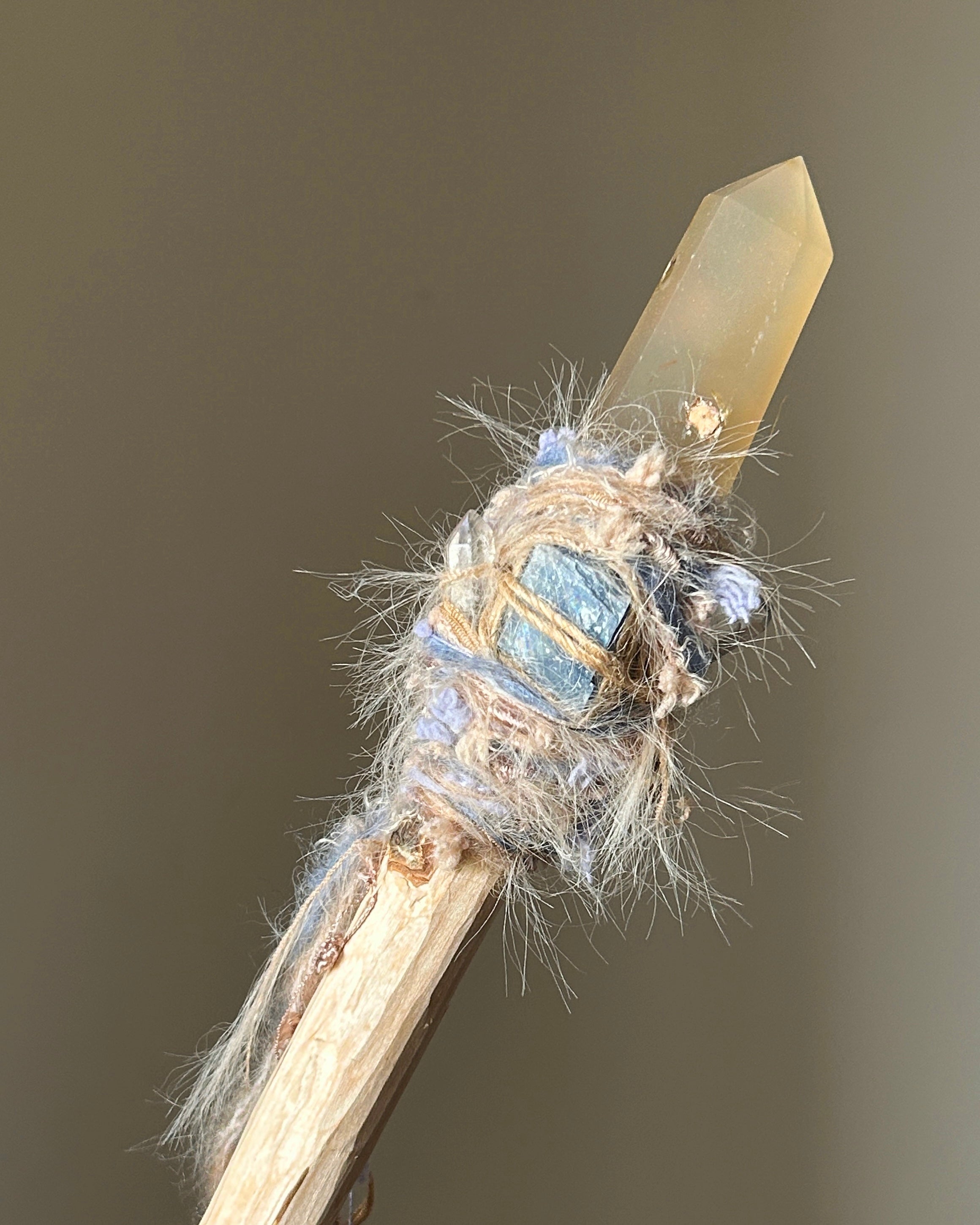 Front view of birch wand with yellow agate point, blue kyanite, and soft fiber wrapping
