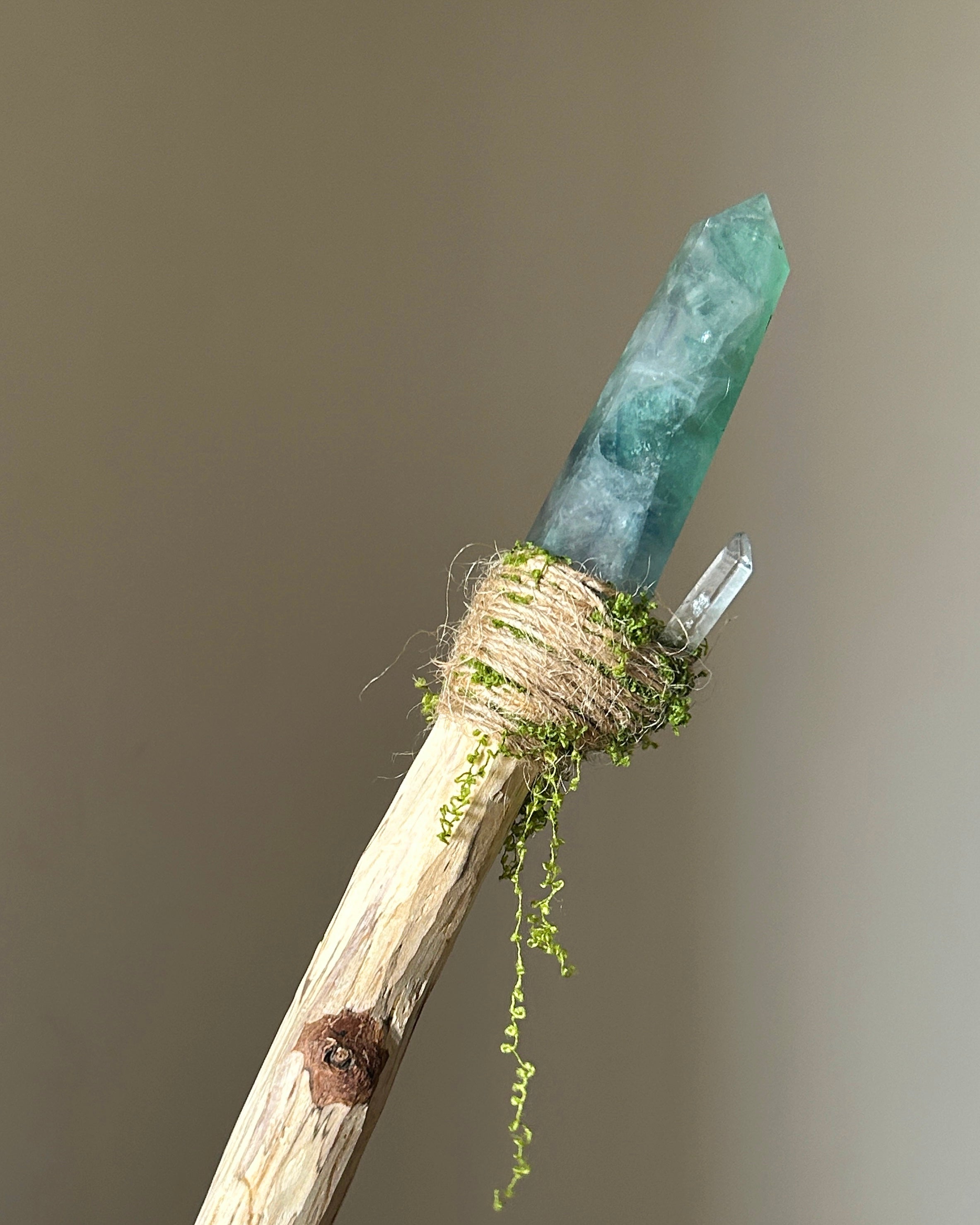 Back view of spring-themed wand with clear quartz detail and flowing moss texture