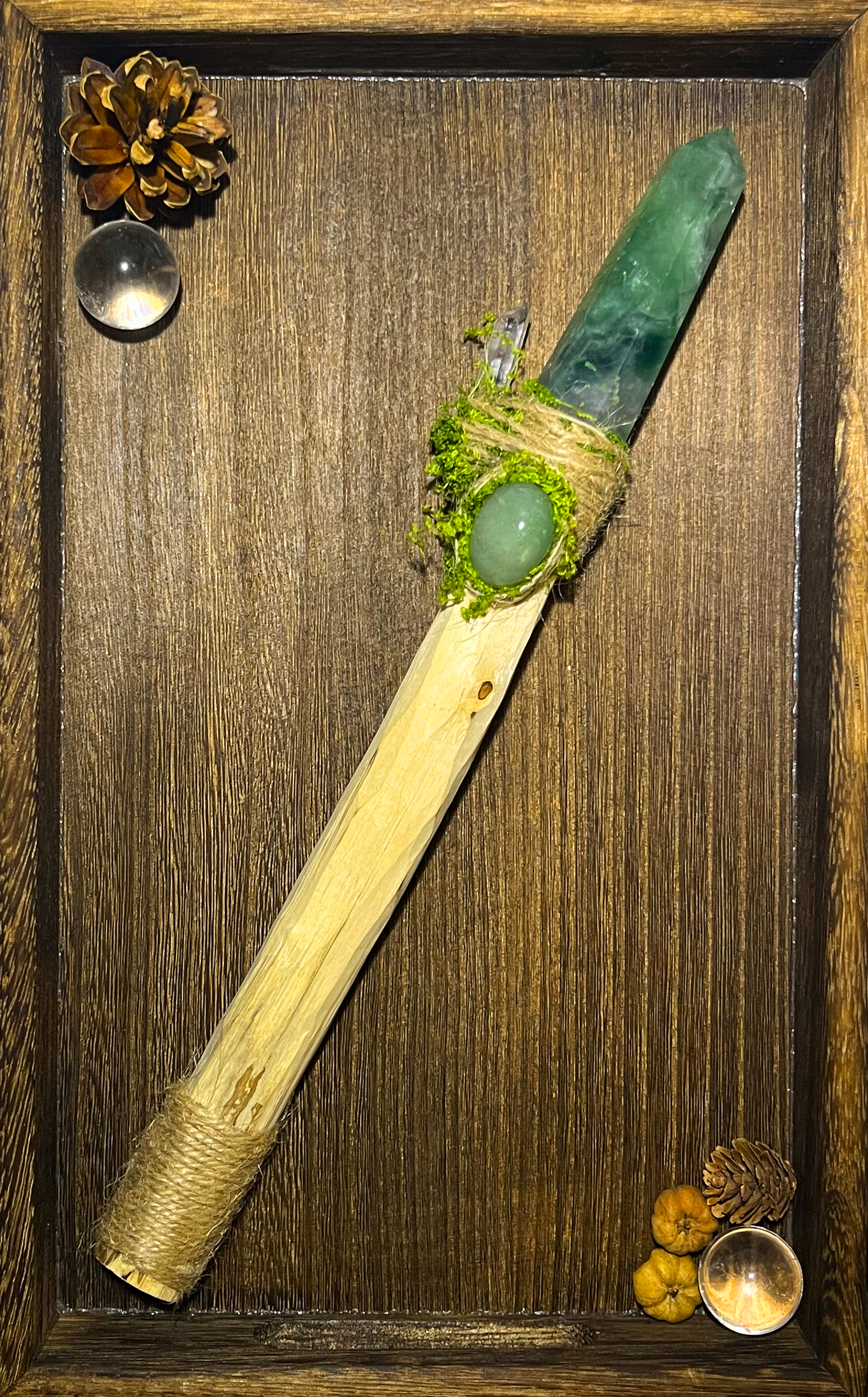 Flat lay of forest spring wand with calming crystals and natural green wrapping