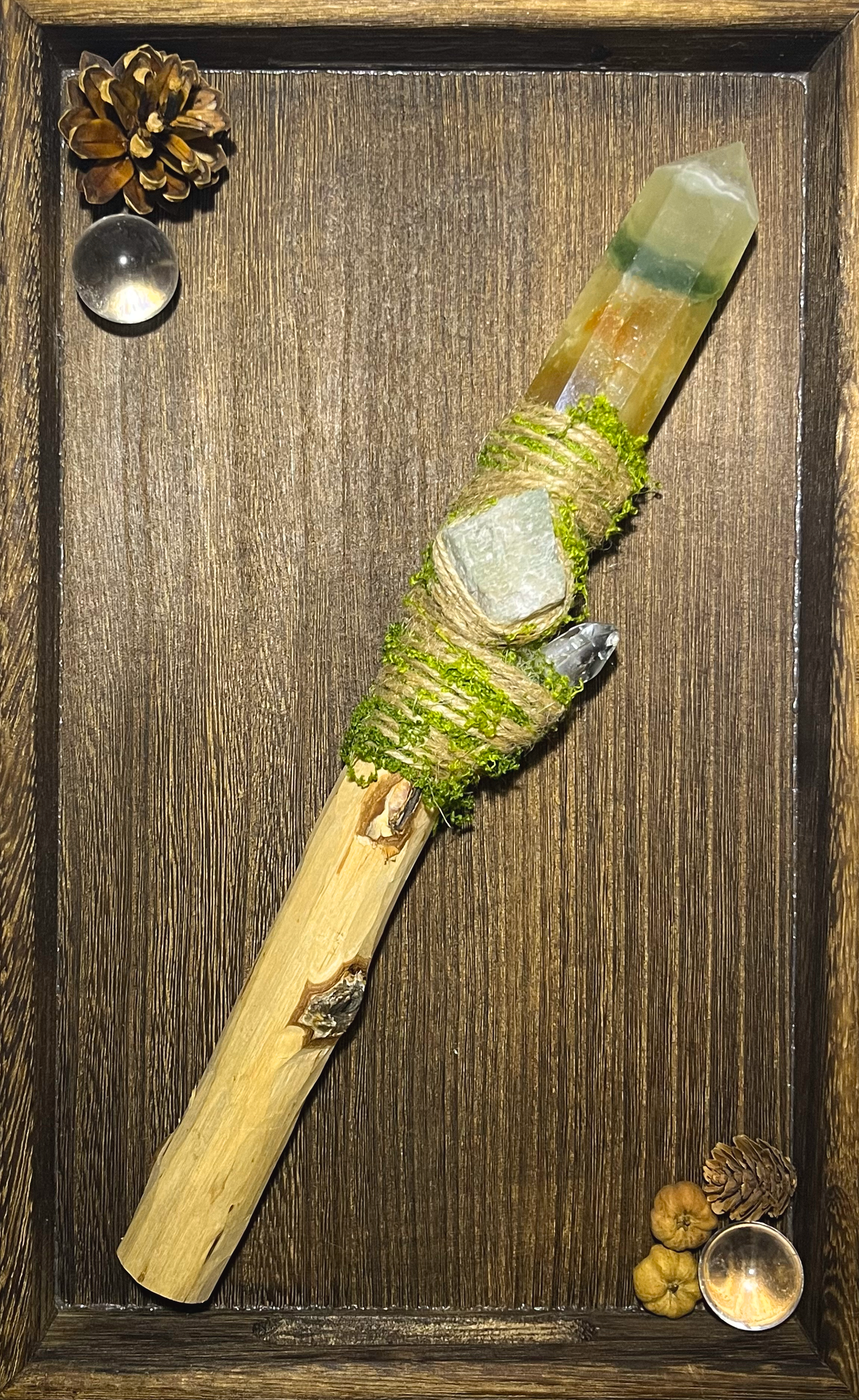 Flat lay of forest-aligned wand with banded fluorite and grounding herbal aesthetic