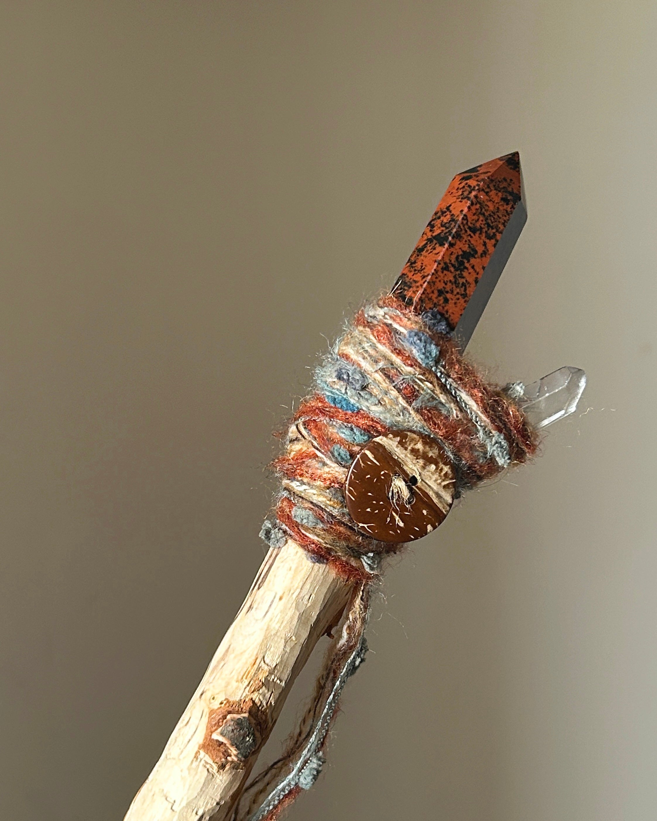 Back view showing wrapped birch handle and obsidian crystal point