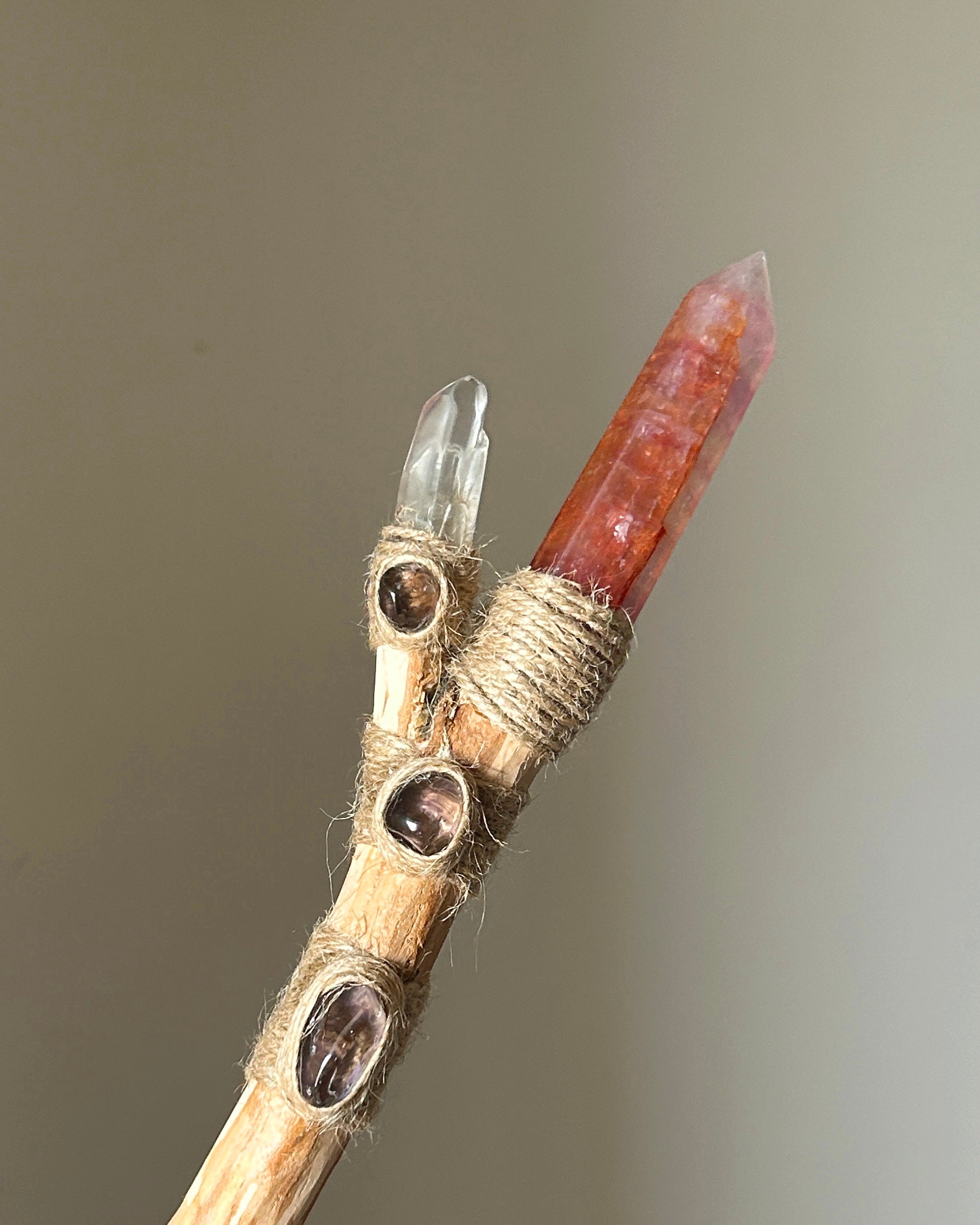 Front view of orange fluorite wand with smoky quartz cabochons and birch wood