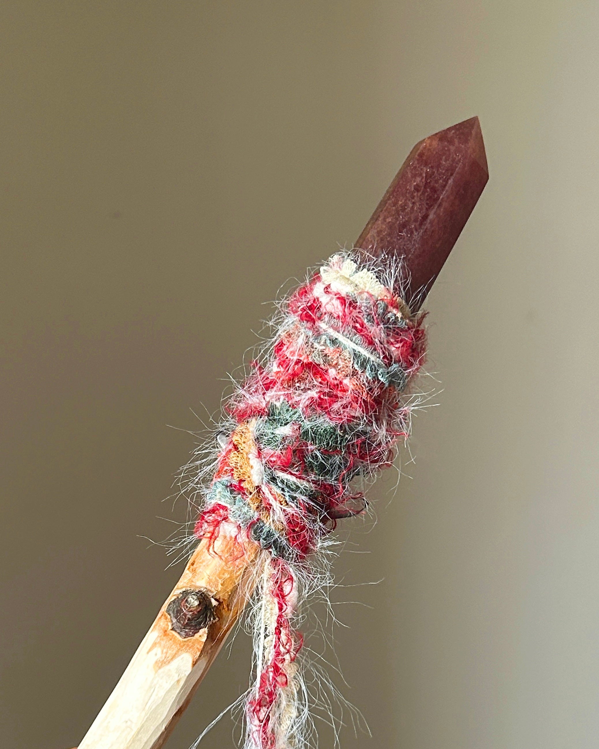 Reverse side of summer-themed magic wand with red and green yarn