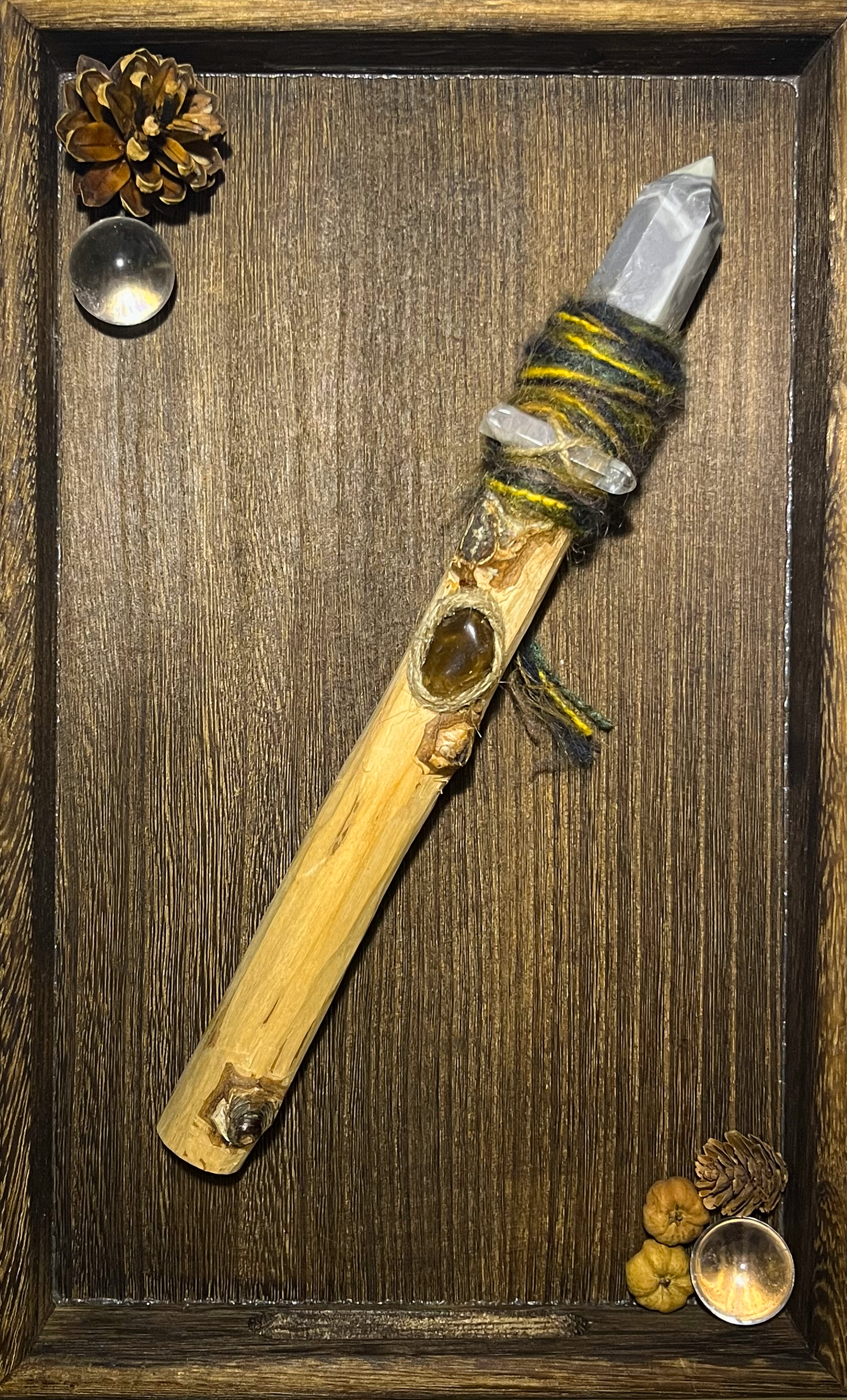 Flat lay of rugged storm-themed wand with embedded grey agate and earthy tone wrapping