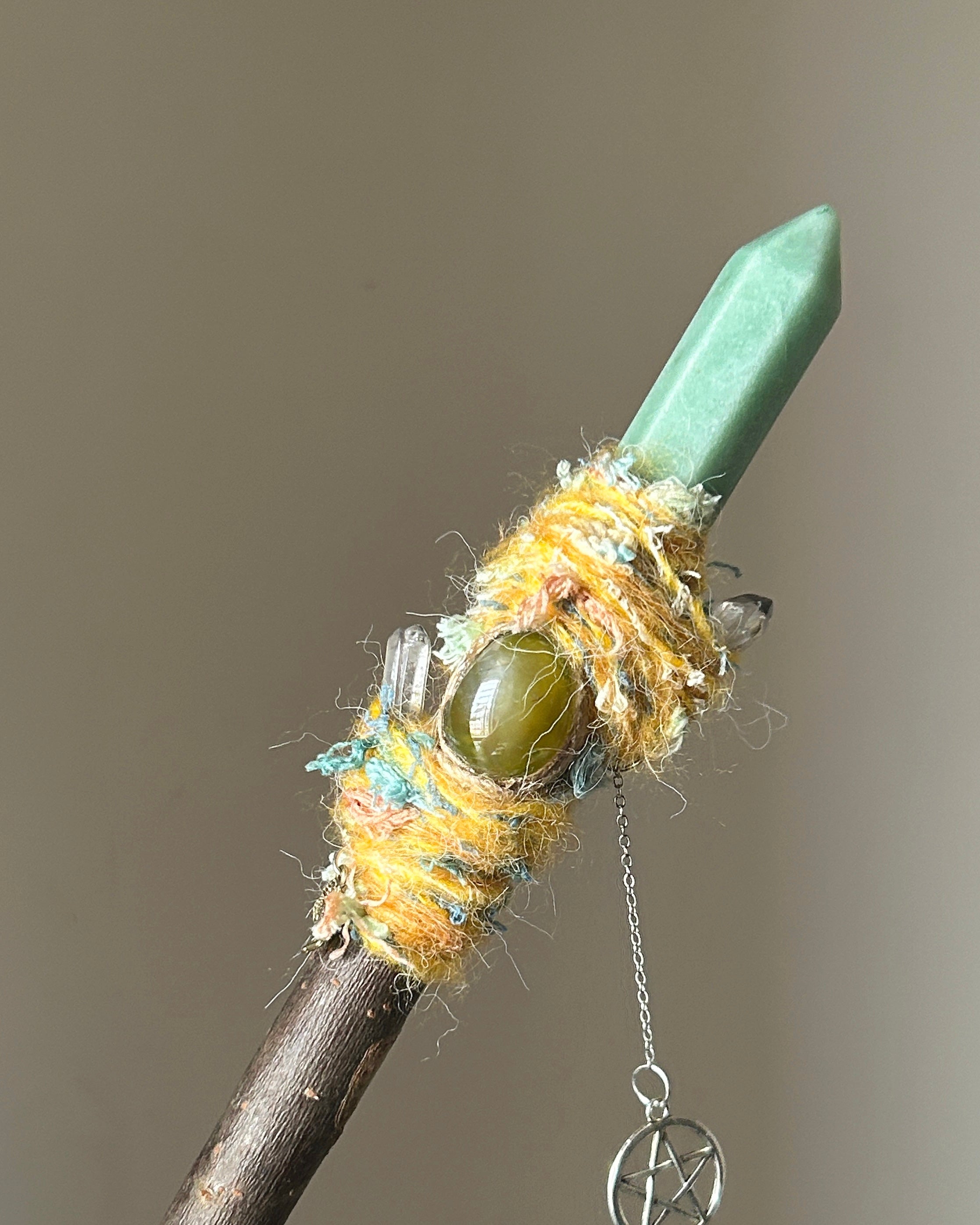 Front view of willow wand with green aventurine point and yellow-blue wrapping
