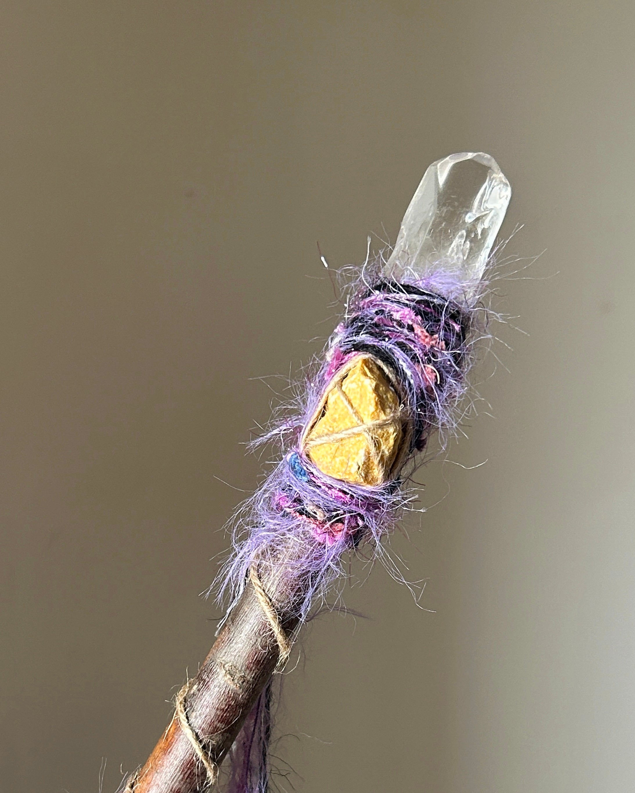 Front view of willow wand with raw clear quartz, yellow jasper, and cosmic thread wrapping
