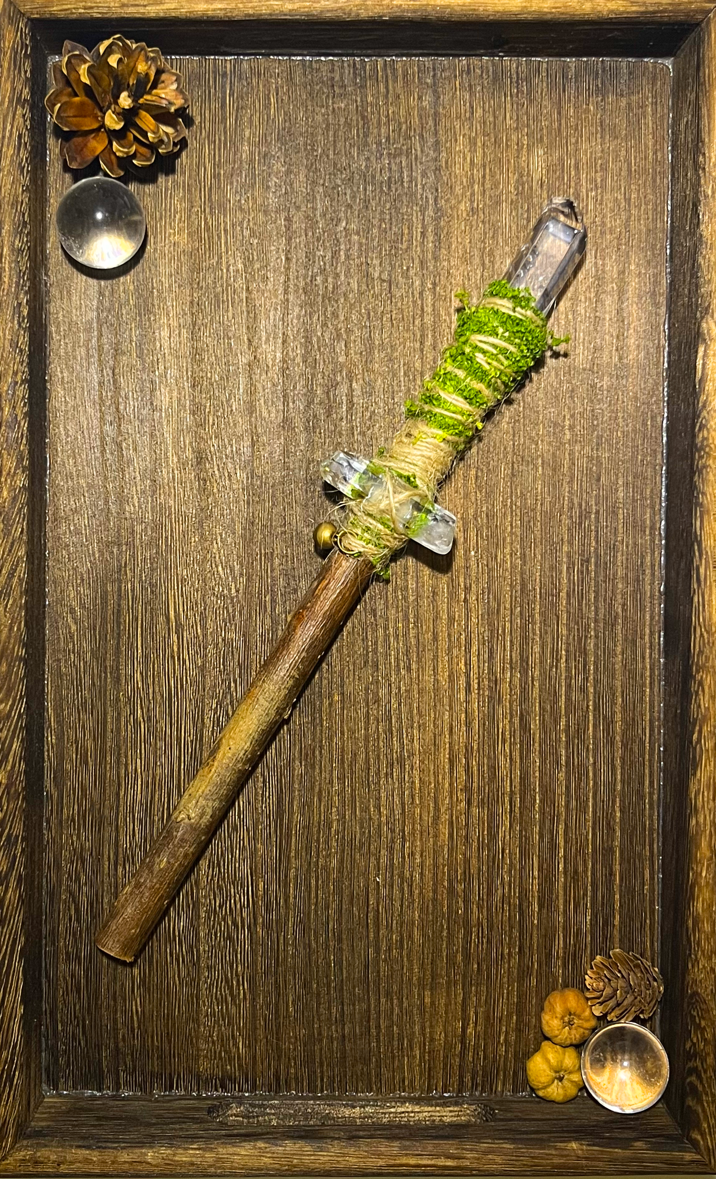 Flat lay of a willow and clear quartz ritual wand displayed on a ceramic plate