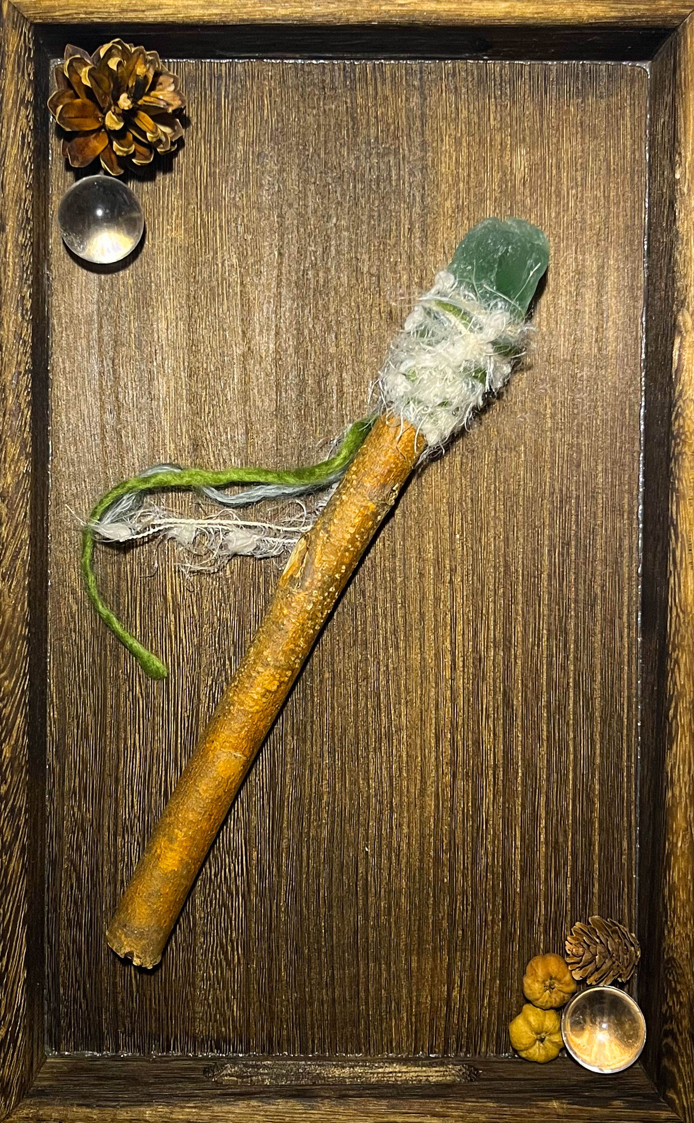 Flat lay of healing wand with green fluorite and mist-like wrapping on ceramic plate