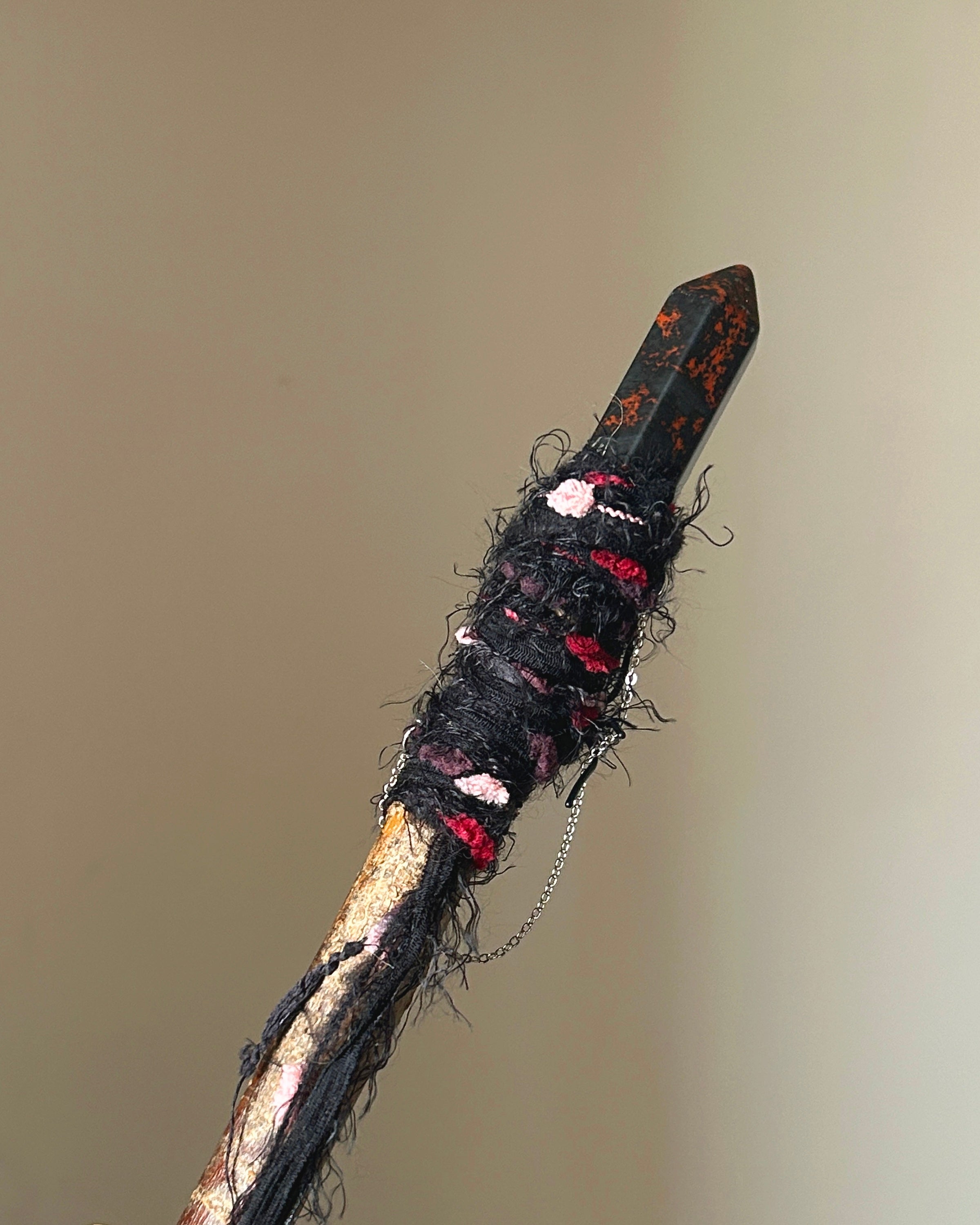 Rear view of willow wand with silver chain and dark fiber wrapping