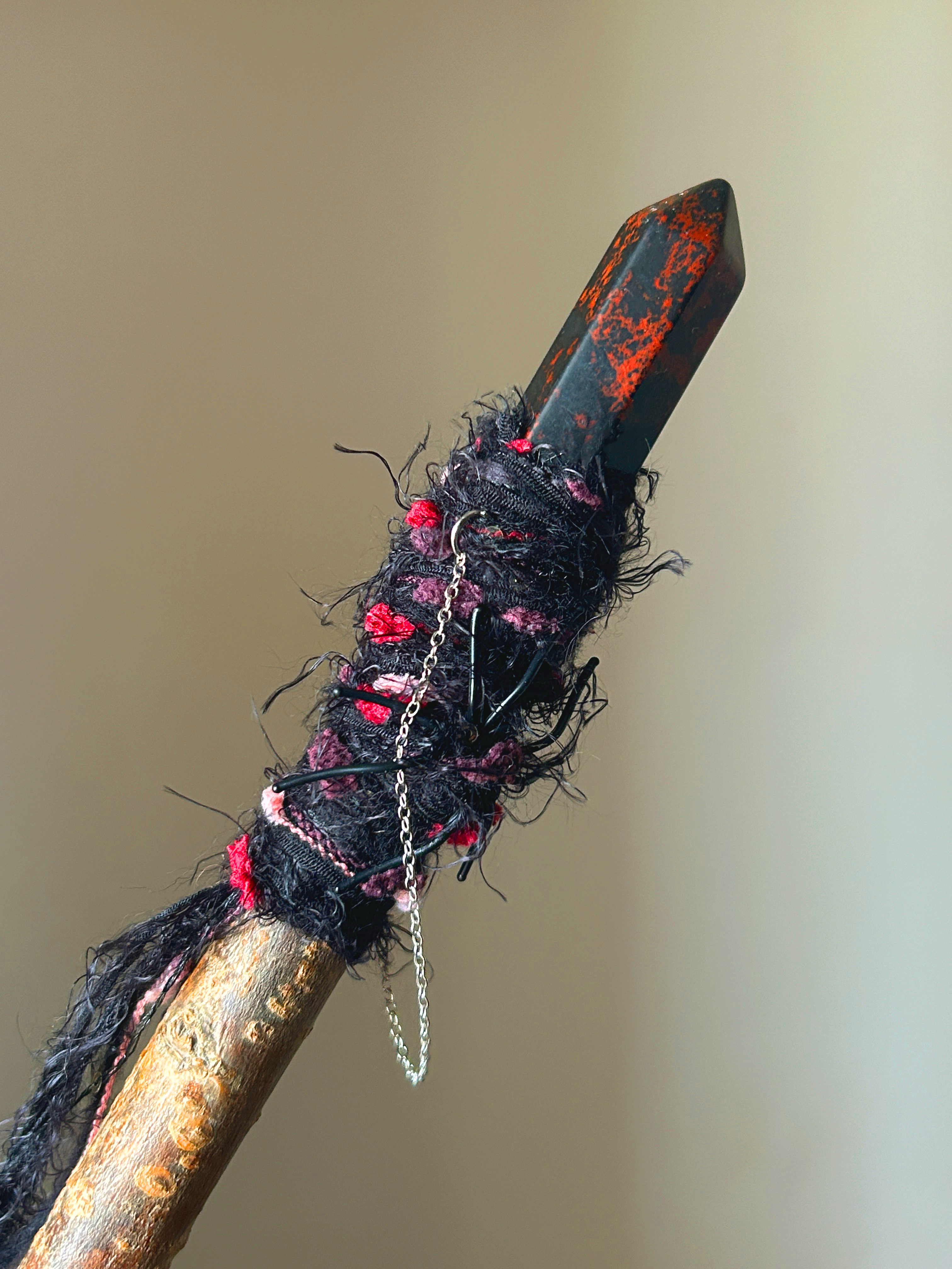 Close-up of polished obsidian point and thread nest with tiny spider