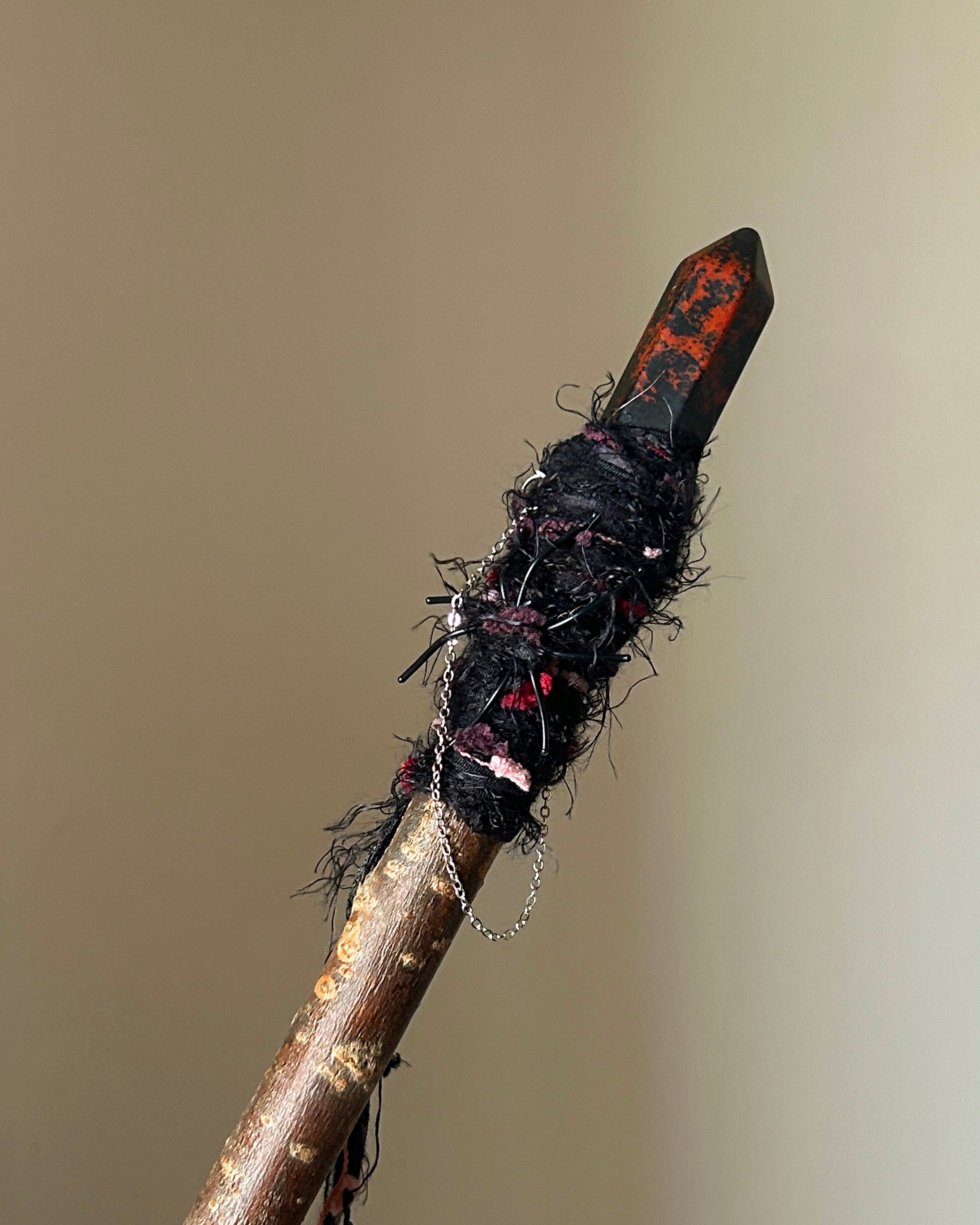 Front view of obsidian wand with black and red threadwrap
