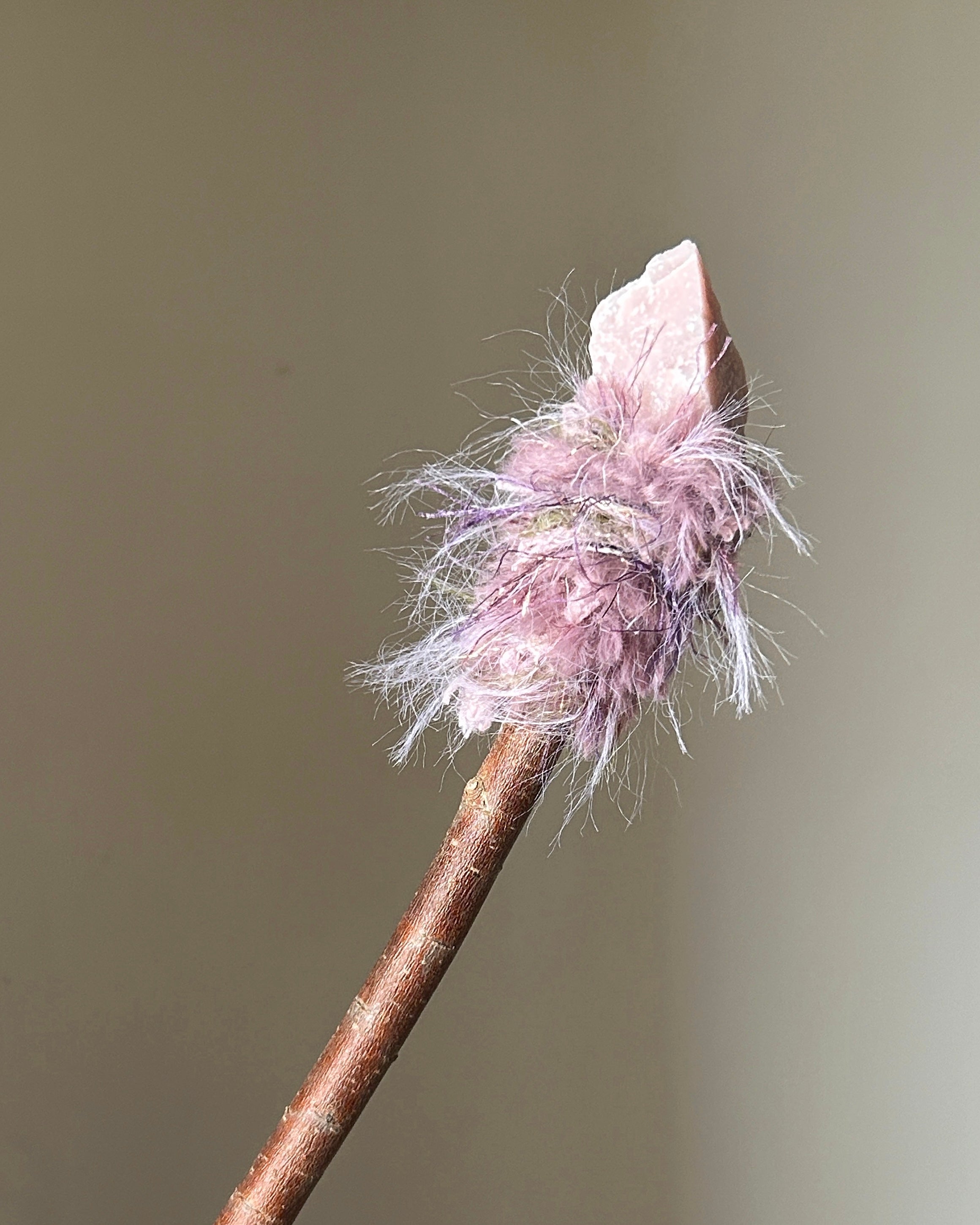 Back view of heart-centered wand with flowing pink threads and raw pink opal