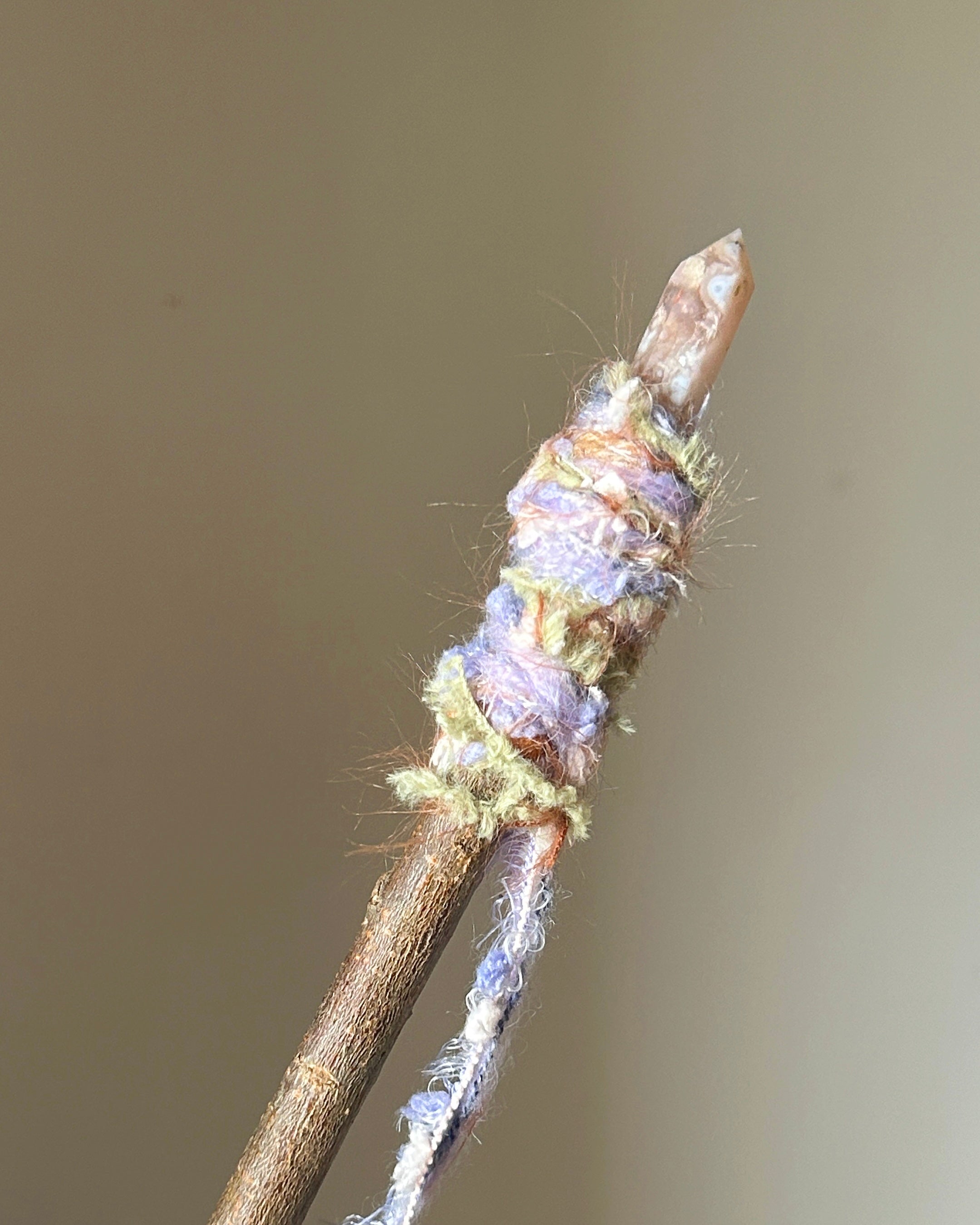 Back view of wand with lavender-pink fibers and green quartz accent