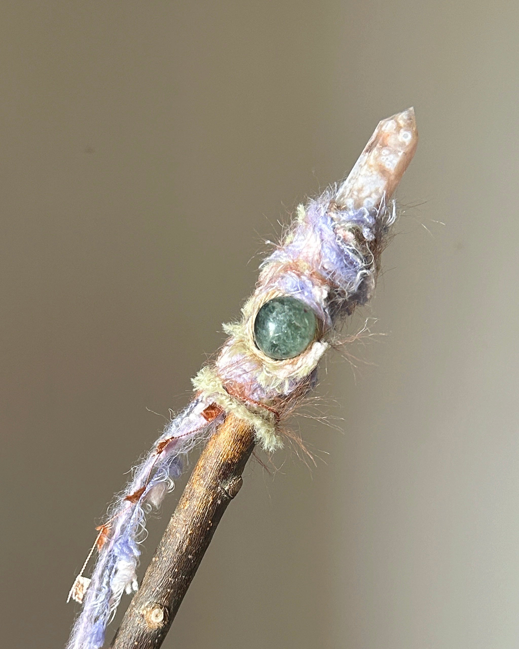 Front view of willow wand with pointed Sakura Agate and soft pastel thread wrapping
