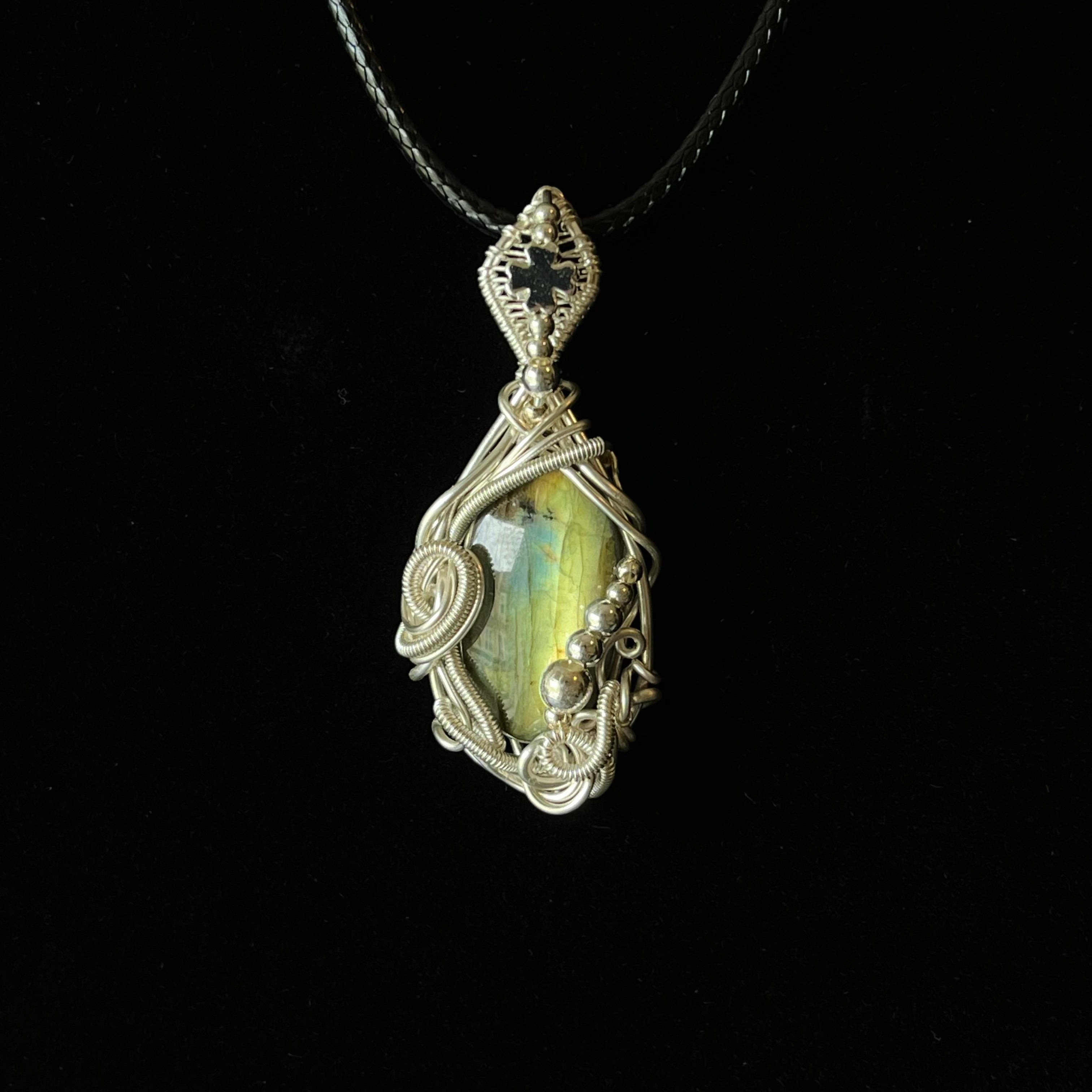 Silver wire-wrapped labradorite pendant with blue-green flash and ornate cross detail
