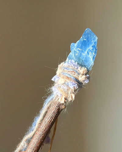 Front view of applewood wand with raw blue calcite and pastel fiber wrapping