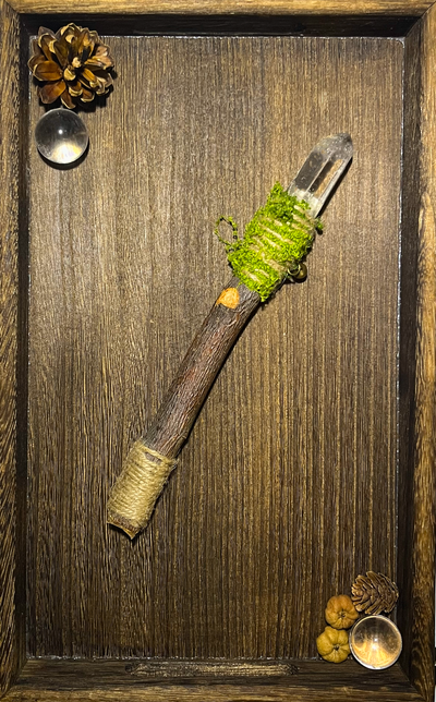 Flat lay of a [wood] and [crystal] wand displayed on a ceramic plate with natural light