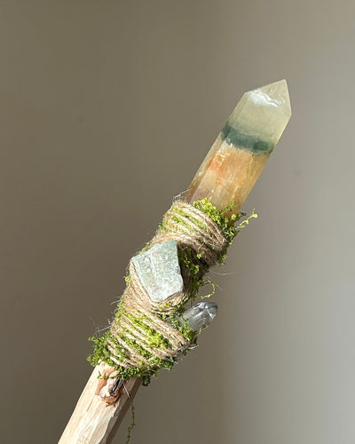 Front view of birch wand with yellow-green fluorite and forest-inspired moss wrapping