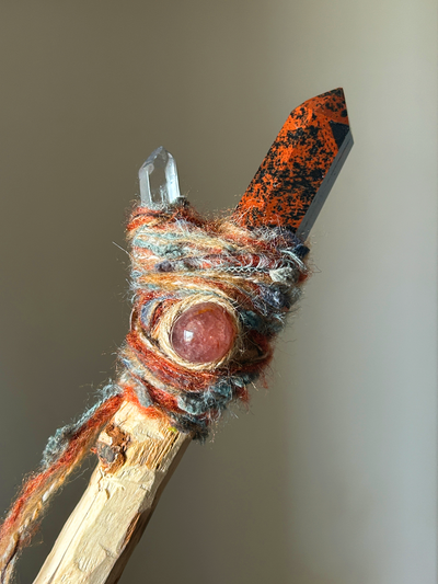 Close-up of obsidian point and pink quartz cabochon on rustic fiber wrap