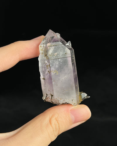 Soft lavender amethyst with self-healed regrowth crystals and a light chlorite coating near the base.4