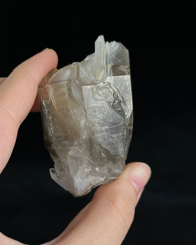 Pale smoky elestial quartz with layered white and reddish clay and companion crystals at the base.2