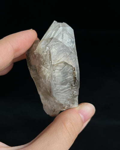 Pale smoky elestial quartz with layered white and reddish clay and companion crystals at the base.3