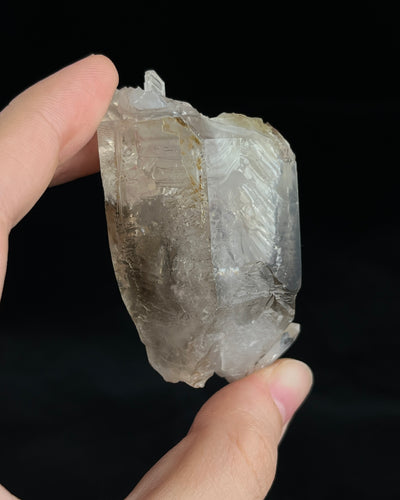 Pale smoky elestial quartz with layered white and reddish clay and companion crystals at the base.4