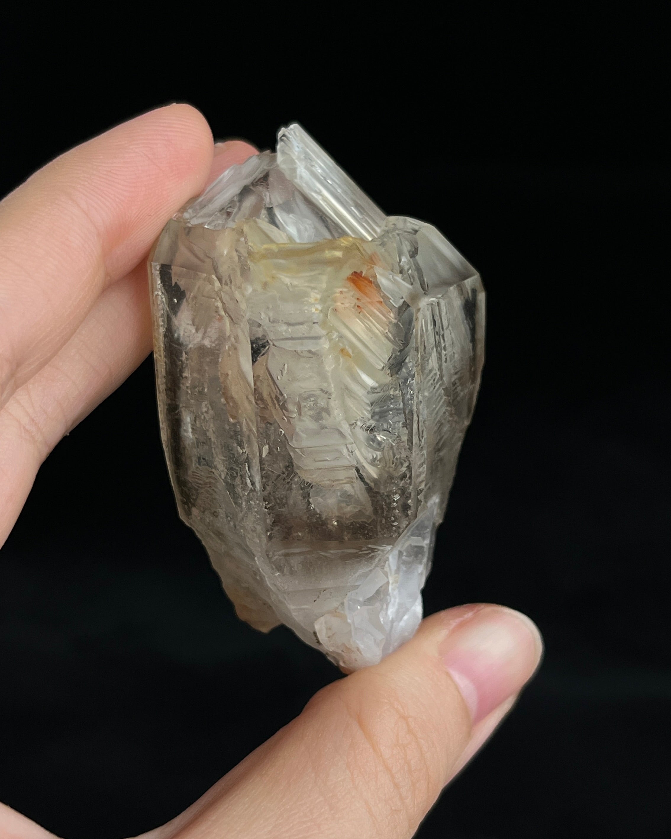 Pale smoky elestial quartz with layered white and reddish clay and companion crystals at the base.5