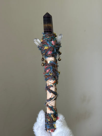 Back view of birch wand wrapped in sky-toned threads with subtle shimmer