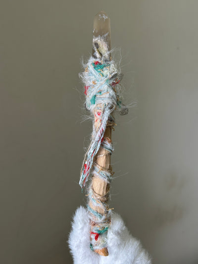 Back view of birch wand with blue and white fiber binding and celestial charms