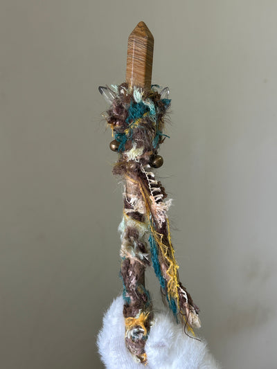Back view of willow wand with golden thread, sun charm, and bells