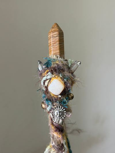 Close-up of picture jasper and calcite cluster on earth-toned wand