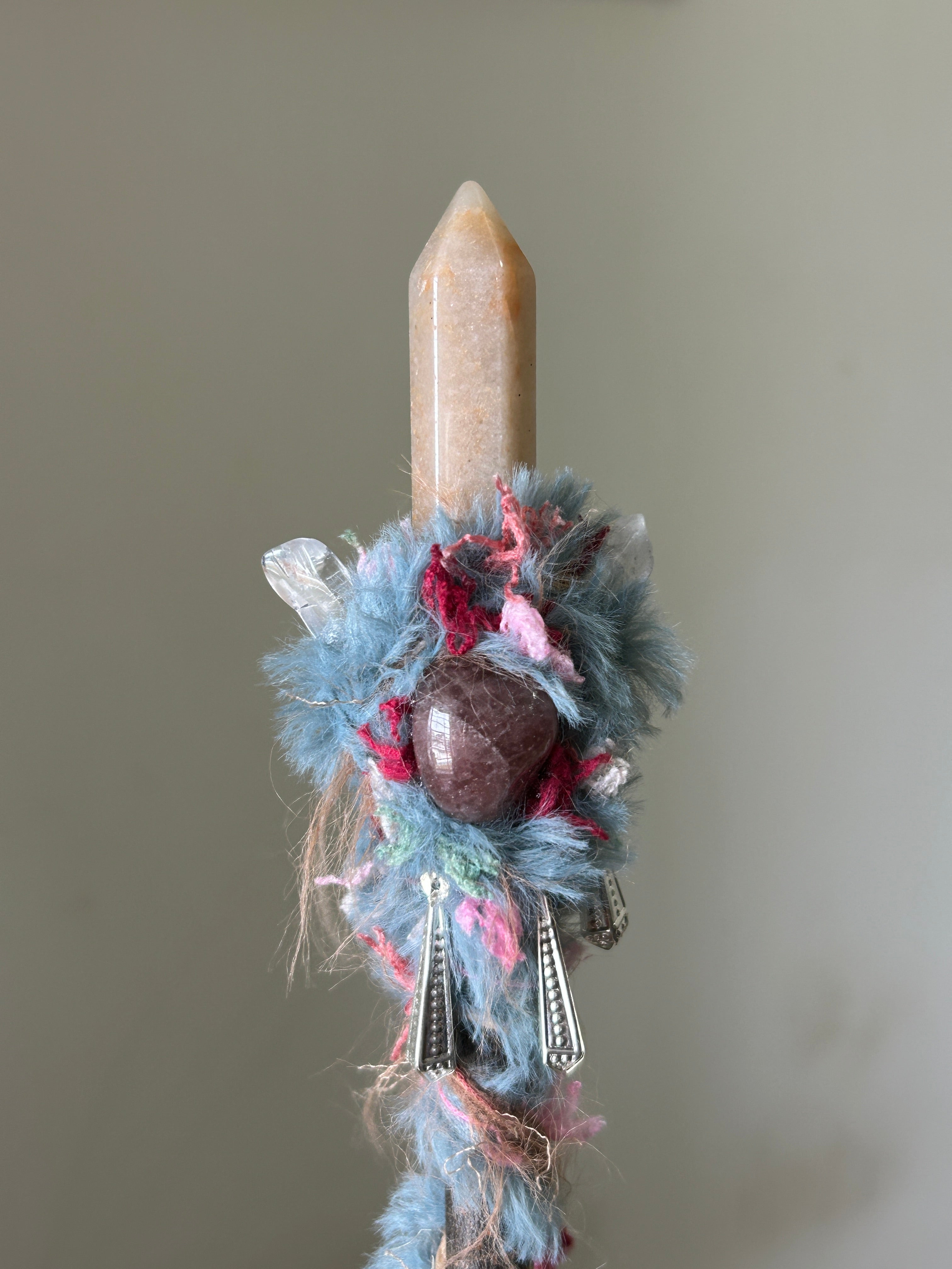 Close-up of strawberry quartz sphere with pink-blue fiber wrap