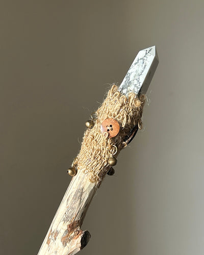 Back view of howlite ritual wand with bronze bells and rustic hemp fiber