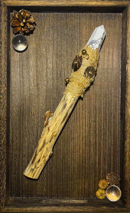 Flat lay of grounding wand with white birch, howlite, and natural textures on ceramic plate