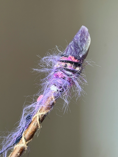 Close-up of pointed amethyst crystal and magical purple-magenta spiral binding