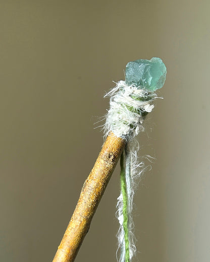 Front view of willow wand with raw green fluorite and soft white-green yarn wrapping
