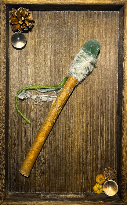 Flat lay of healing wand with green fluorite and mist-like wrapping on ceramic plate